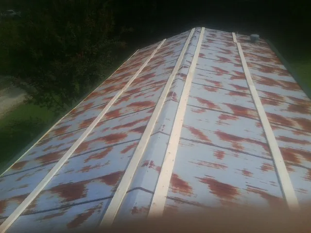 Rusted metal roof panels with new wood purlins before replacement — Storm Damage Roof Repair in Leonardville by Roofing Brothers