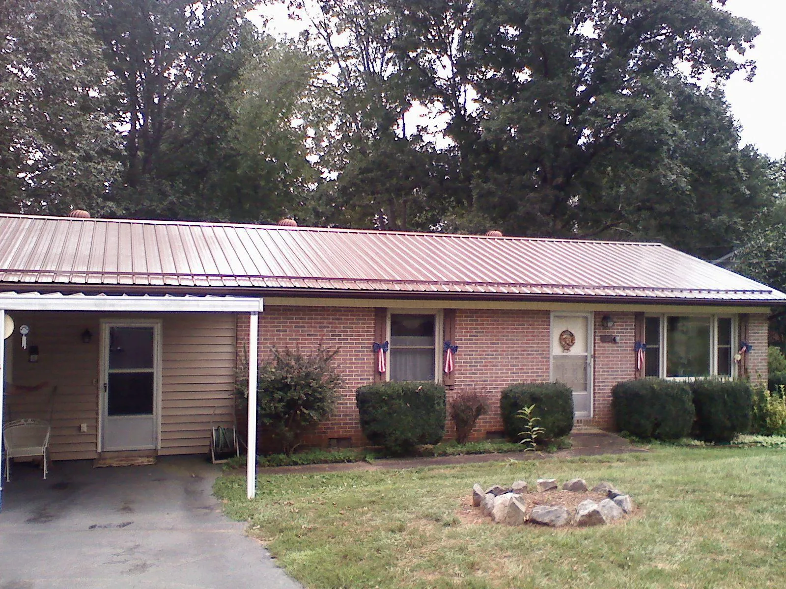 Bronze metal roof and carport on a brick ranch home — Roof Repair work by our crew in Leonardville